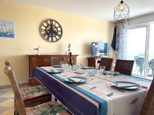 mesa de comedor con mantel azul y blanco en Appartement L'Aiguillon-sur-Vie, 3 pièces, 6 personnes - FR-1-224-797, en LʼAiguillon-sur-Vie