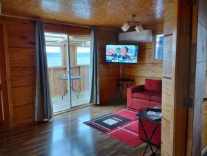 a living room with a red couch and a tv at Cabañas Lomas de Ten Ten in Castro