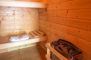a wooden sauna with a tub and logs in it at Apartment am Wirschbach in Weiersbach