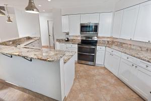 a kitchen with white cabinets and granite counter tops at Bali Bay 401 OV Myrtle Beach Hotel Room in Myrtle Beach