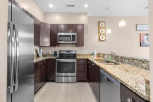 a kitchen with stainless steel appliances and wooden cabinets at Bali Bay 404 OV Myrtle Beach Hotel Room in Myrtle Beach