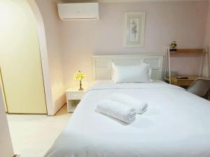 1 dormitorio con 1 cama blanca grande y toallas. en Apple House Hoppers Crossing, en Tarneit