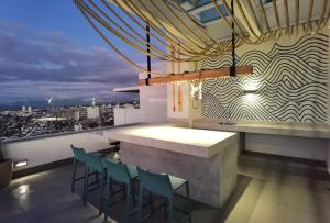 a bar with chairs and a view of a city at Exquisito Departamento a pasos de la playa en mejor sector de Reñaca y Concón in Concón