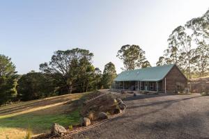 a barn on a hill next to a road at The Lodge Daylesford in Hepburn