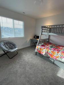 a bedroom with a bed and a chair and a window at NEW 4-bed 4-bath Stylish House with Mountain View and 2 garages in Lehi +26 photos