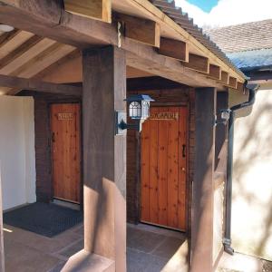 un edificio con puertas de madera con una luz en él en Beautiful 1-Bed Lodge in Clifford Hereford, en Hereford