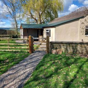 a house with a fence next to a field at Beautiful 1-Bed Lodge in Clifford Hereford in Hereford