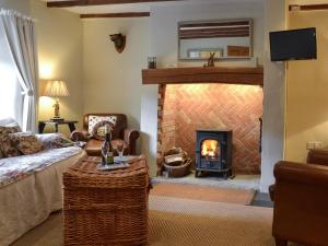 a living room with a fireplace and a couch at Norfolk House in Dulverton