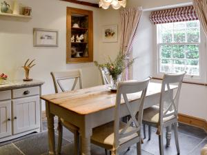 a kitchen with a wooden table and chairs at Norfolk House in Dulverton