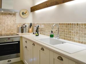 a kitchen with a sink and a stove at Norfolk House in Dulverton