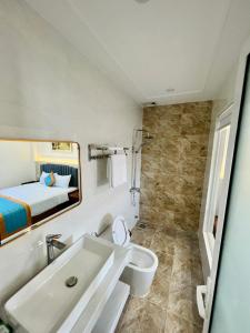 Kinh DinhにあるKHÁCH SẠN Biển Xanhのバスルーム(洗面台、トイレ付)、ベッド1台が備わります。