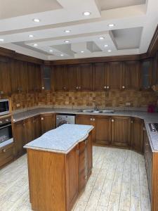 une grande cuisine avec des placards en bois et un comptoir. dans l'établissement مدينه نصر مكرم عبيد, au Caire