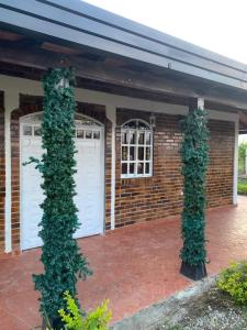 a brick building with two white garage doors and ivy at PARCELA VILLA PAU in Lebrija