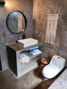 uma casa de banho com um lavatório, um WC e um espelho. em San MARTÍN em Cozumel