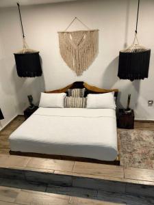 a bedroom with a white bed and two hanging baskets at San MARTÍN in Cozumel