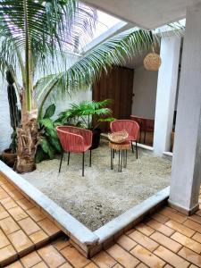 un patio con sillas, una mesa y palmeras en San MARTÍN, en Cozumel