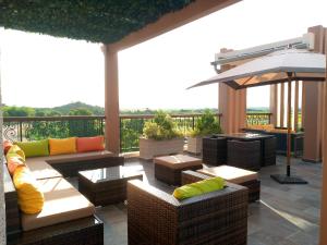 a patio with couches and tables and an umbrella at SOA LIA HOTEL in Miandrivazo