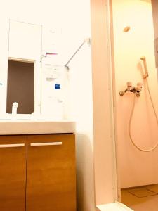 y baño con lavabo y ducha con espejo. en Guest House Kirara - Vacation STAY 88539 en Osaka