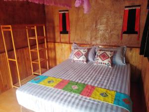 a bedroom with a bed with pillows and a shelf at Diềm Bungalow in Ha Giang