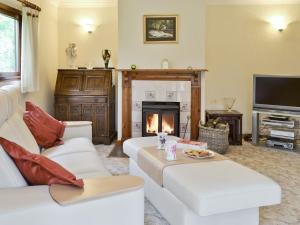 a living room with two white couches and a fireplace at Glan Gors in Tregaron