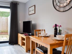 a dining room with a table and a television at Carr Lodge in York