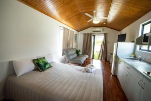 a small bedroom with a bed and a kitchen at Sarina Palms Caravan and Cabins Village in Sarina