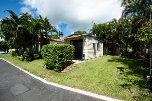 a small house on the side of a street at Sarina Palms Caravan and Cabins Village in Sarina