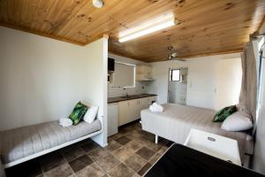 a room with two beds and a kitchen at Sarina Palms Caravan and Cabins Village in Sarina