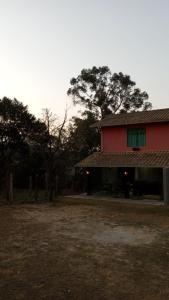 uma casa com um edifício vermelho e árvores ao fundo em Espaço Lavras Novas em Lavras Novas