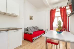 a living room with a red couch and a table at Central Jardin Guest House Split in Split