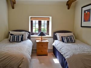 two twin beds in a room with a window at The Granary in Lucy Cross