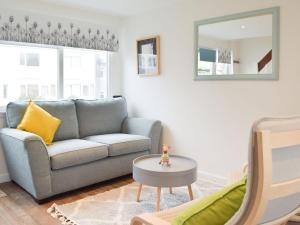 a living room with a couch and a mirror at Sanderling - Uk32837 in Hodgeston