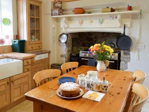 a kitchen with a wooden table with a cake on it at Dunley Farmhouse in Bovey Tracey