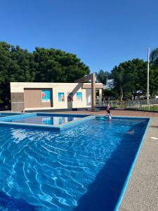 a person is standing in a blue swimming pool at Lujo, mar, seguridad y diversión en la mejor zona de Manta. in Manta