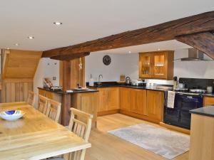 eine Küche mit Holzschränken und einem Holztisch in der Unterkunft The Barn in Ropley