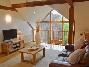 a living room with a couch and a tv at The Barn in Ropley