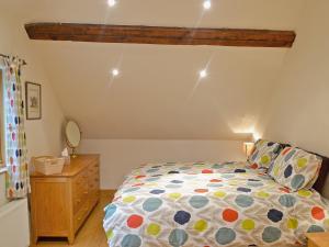 ein Schlafzimmer mit einem Bett und einer Holzkommode in der Unterkunft The Barn in Ropley