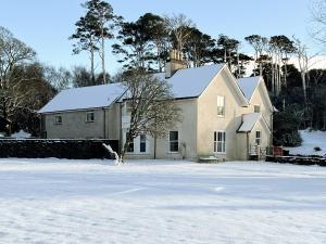 a house with snow on the ground in front of it at Suisnish House in Ollach