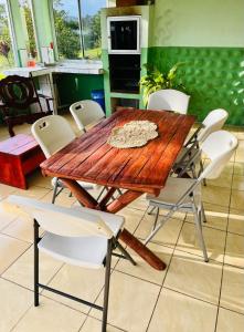uma mesa de madeira e cadeiras numa cozinha em Miravalles Volcano House em Guayabal