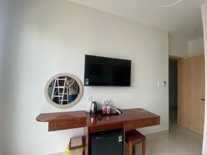 a room with a tv and a table with a mirror at KHÁCH SẠN Biển Xanh in Kinh Dinh
