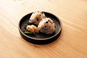 une assiette de nourriture avec des sushis sur une table en bois dans l'établissement Baby Friendly Hotel Grapevine Kyoto, à Kyoto