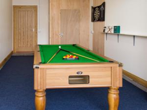 a pool table in a room with a green cloth at Seascape in Mainsriddle