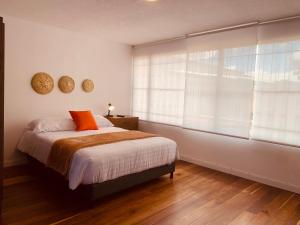 - une chambre avec un lit et une grande fenêtre dans l'établissement CASA CREAZZO 62 - Movistar Arena, à Bogotá