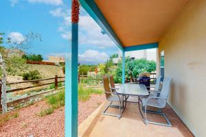 d'une terrasse avec une table, des chaises et une clôture. dans l'établissement Casa Vistoso, à Santa Fe