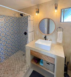 a bathroom with a sink and a shower with a mirror at 3 Bed 4 bath Ocean View with Heated Pool. in El Pueblito