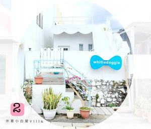 Biały dom ze schodami i znakiem, który czyta białą radość w obiekcie Whitiedoggie Villa II w mieście Checheng