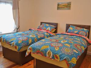 フォーディングブリッジにあるBerts Cottageのベッドルーム1室(ツインベッド2台、カラフルな毛布付)