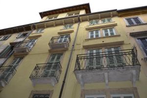 a tall yellow building with windows and balconies at Dimora 4 Spade in Verona