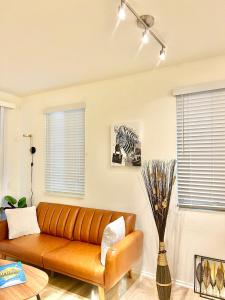 sala de estar con sofá de cuero y una foto de cebra en Le Jardin - Remote Work Getaway in SoCal, en Irvine