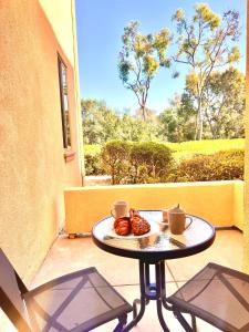 a table with a plate of food on a balcony at Le Jardin - Remote Work Getaway in SoCal in Irvine